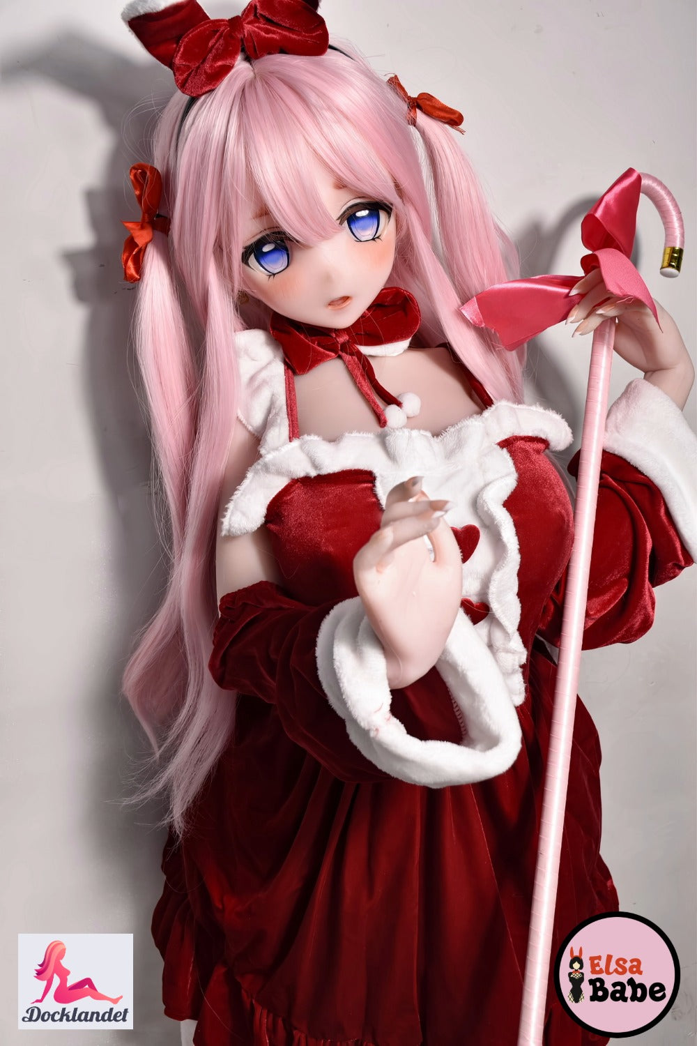 ElsaBabe Itsuki Sango 148 cm anime waifu-docka, bär röd och vit julklänning med rosetter, rosa hår och blå ögon, håller en rosa stav med stor rosett.